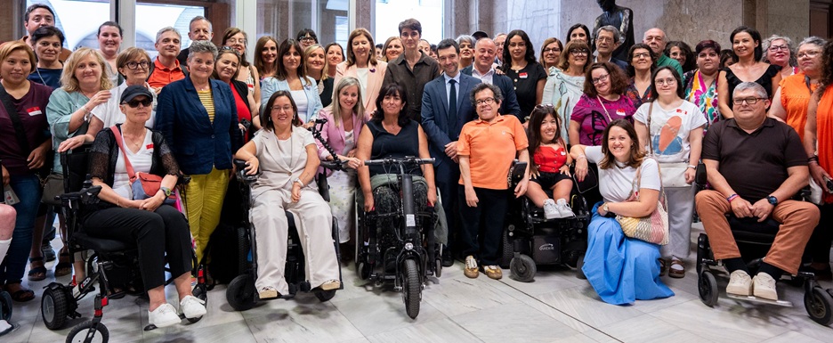 El ministro Pablo Bustinduy con personas asistentes al pleno del Congreso de los Diputados en el que se ha aprobado la reforma de la Ley de discapacidad y la refundación del sistema de dependencia.